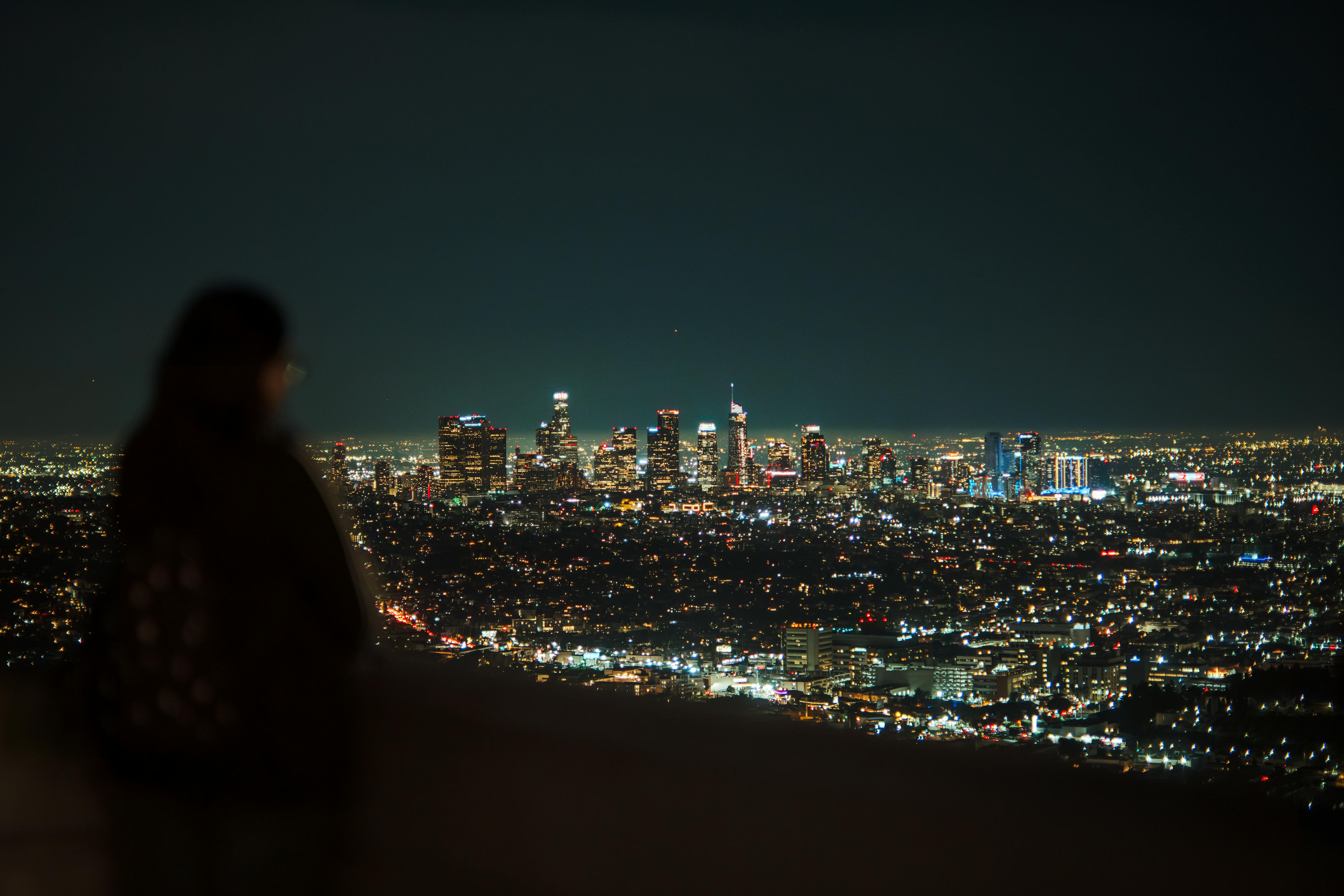 women overlooking city at night