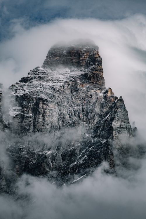Free Dramatic view of a snow-covered mountain peak shrouded in clouds, creating a mysterious and scenic landscape. Stock Photo