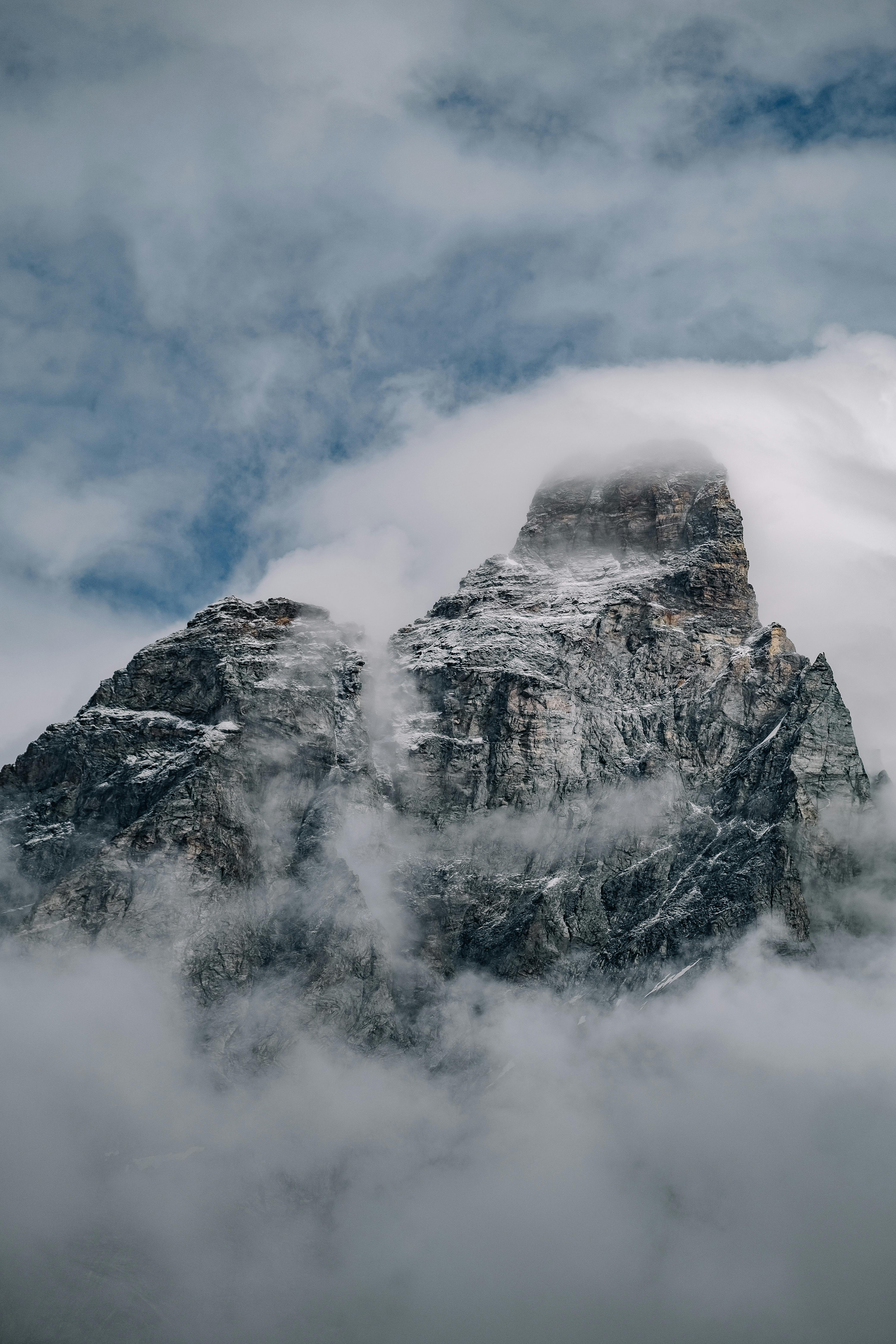 A striking image of a mountain peak shrouded in fog and snow, evoking a sense of mystery and adventure.