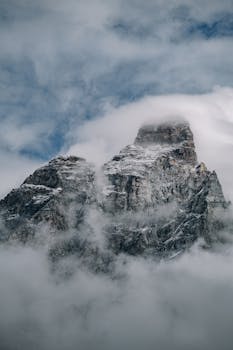 A striking image of a mountain peak shrouded in fog and snow, evoking a sense of mystery and adventure.