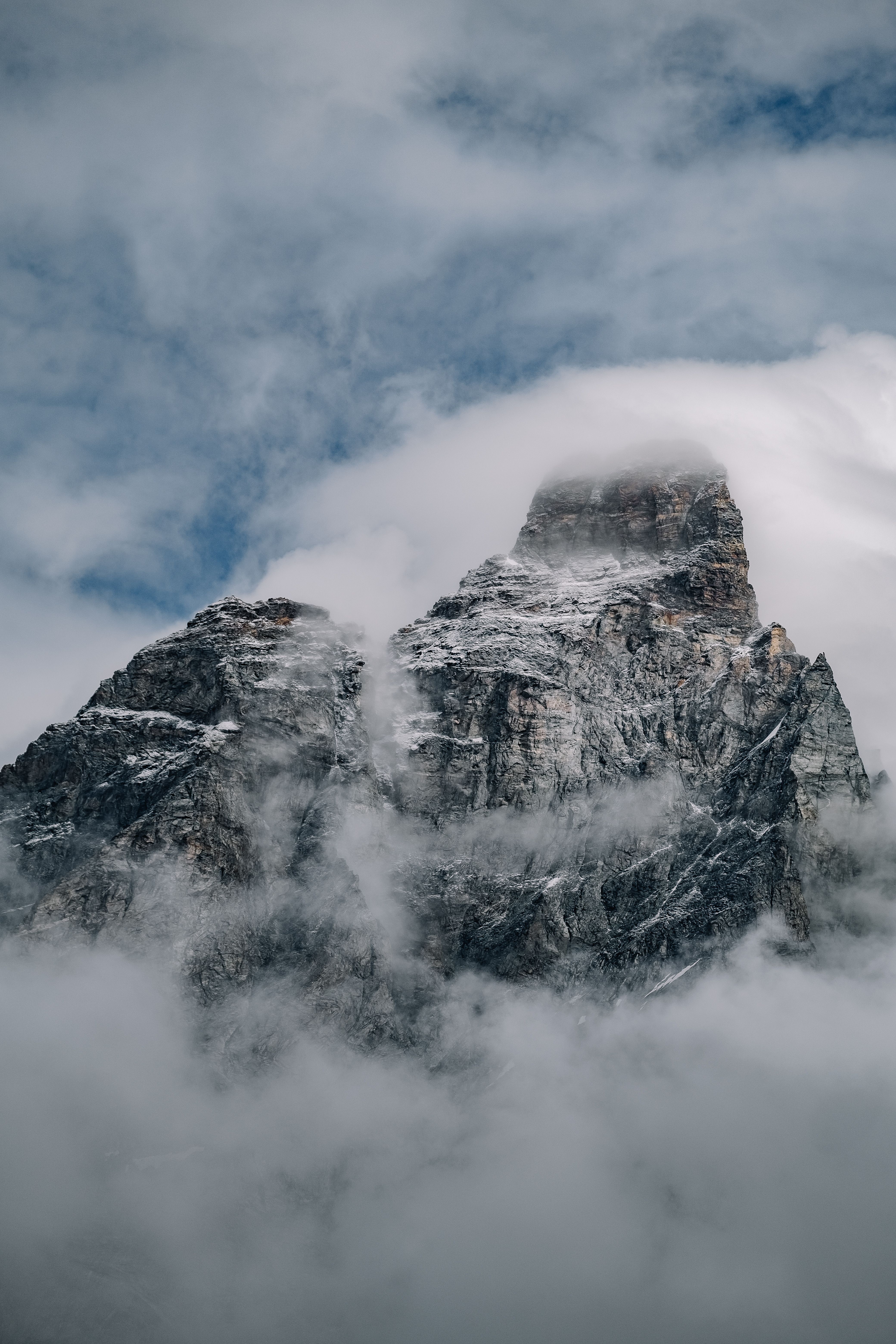 A mountain covered in clouds and fog · Free Stock Photo