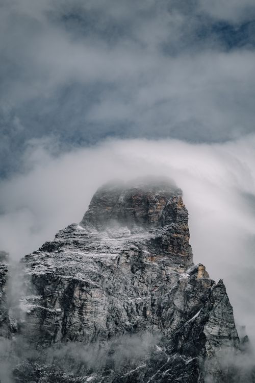 Free Snow-covered mountain peak shrouded in mist, creating a dramatic and serene landscape. Stock Photo