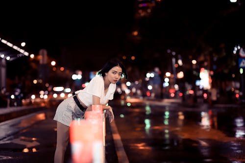 Woman Wearing White Top Leaning on Road Fence