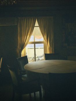 Warm and inviting room with sunlight filtering through elegant curtains, casting soft shadows on furniture.