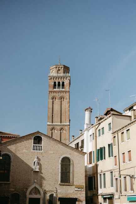 Capture of a historic Venetian tower and nearby buildings on a sunny day, showcasing classic architecture.