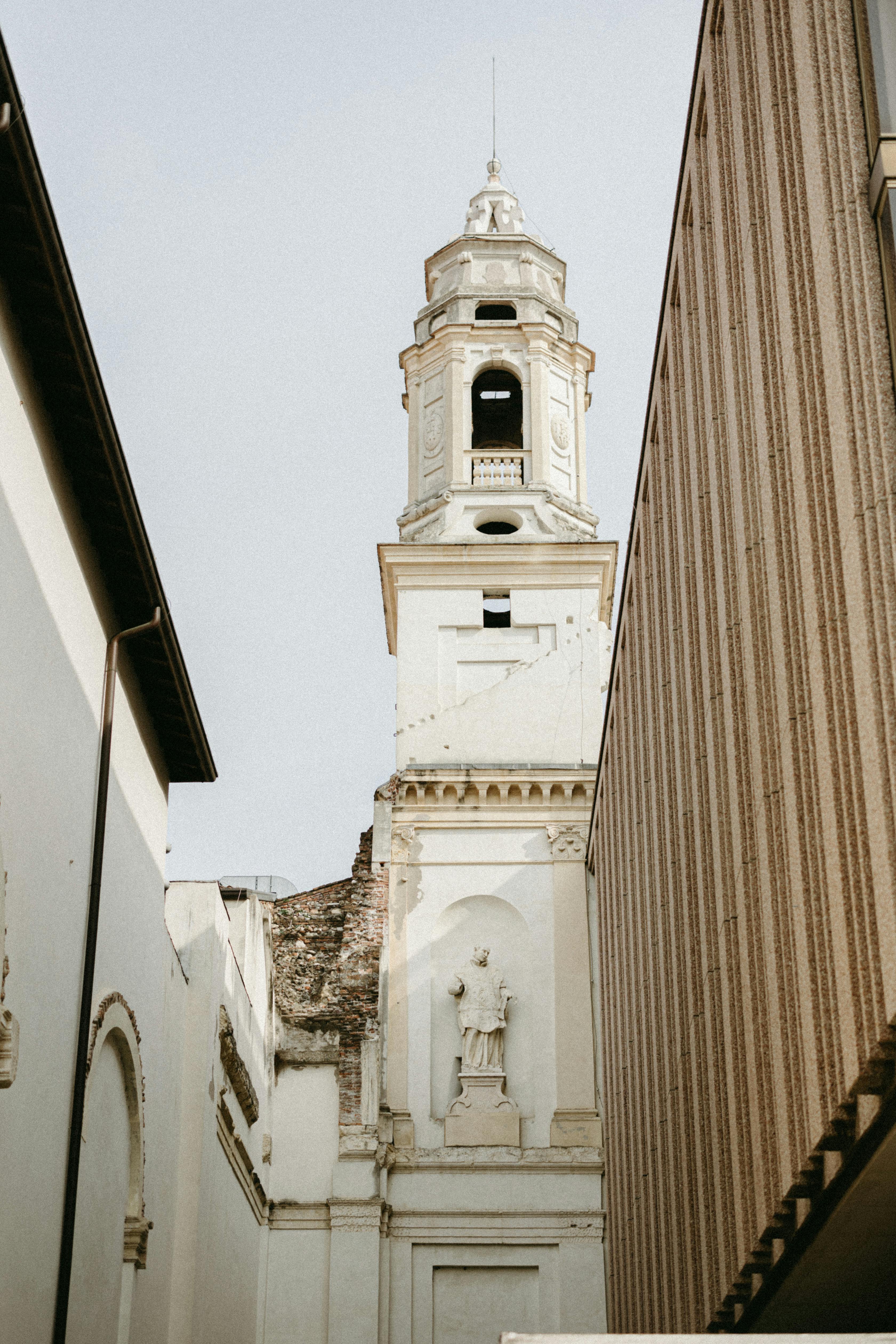 Gothic tower framed by modern urban architecture, capturing historical and urban contrast.