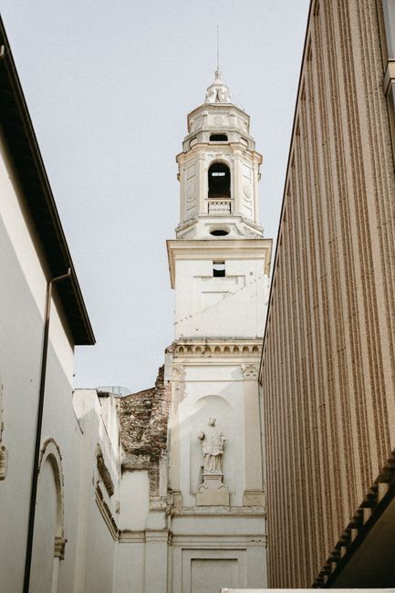 Gothic tower framed by modern urban architecture, capturing historical and urban contrast.