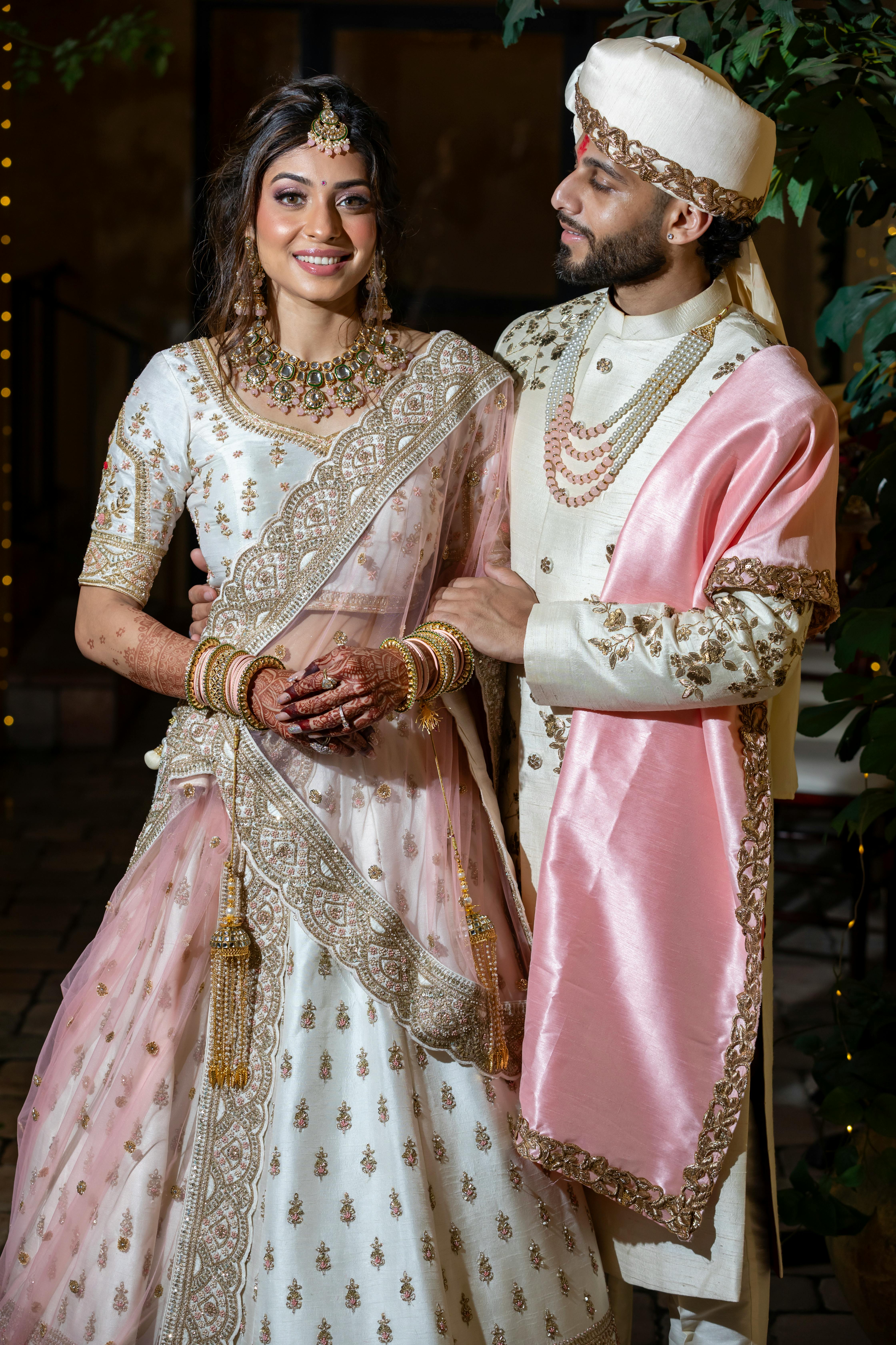 a couple in traditional indian attire posing for a photo