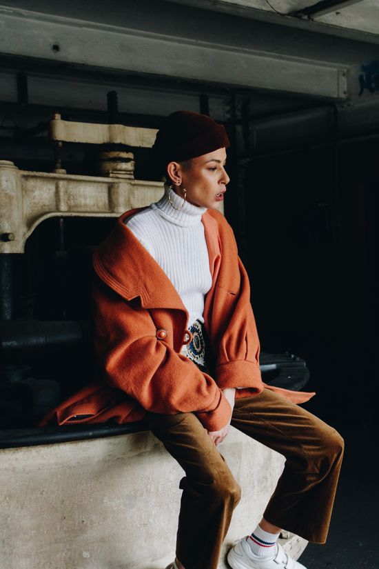 Portrait of a woman in a vintage orange coat — photo by Kamay on Pexels
