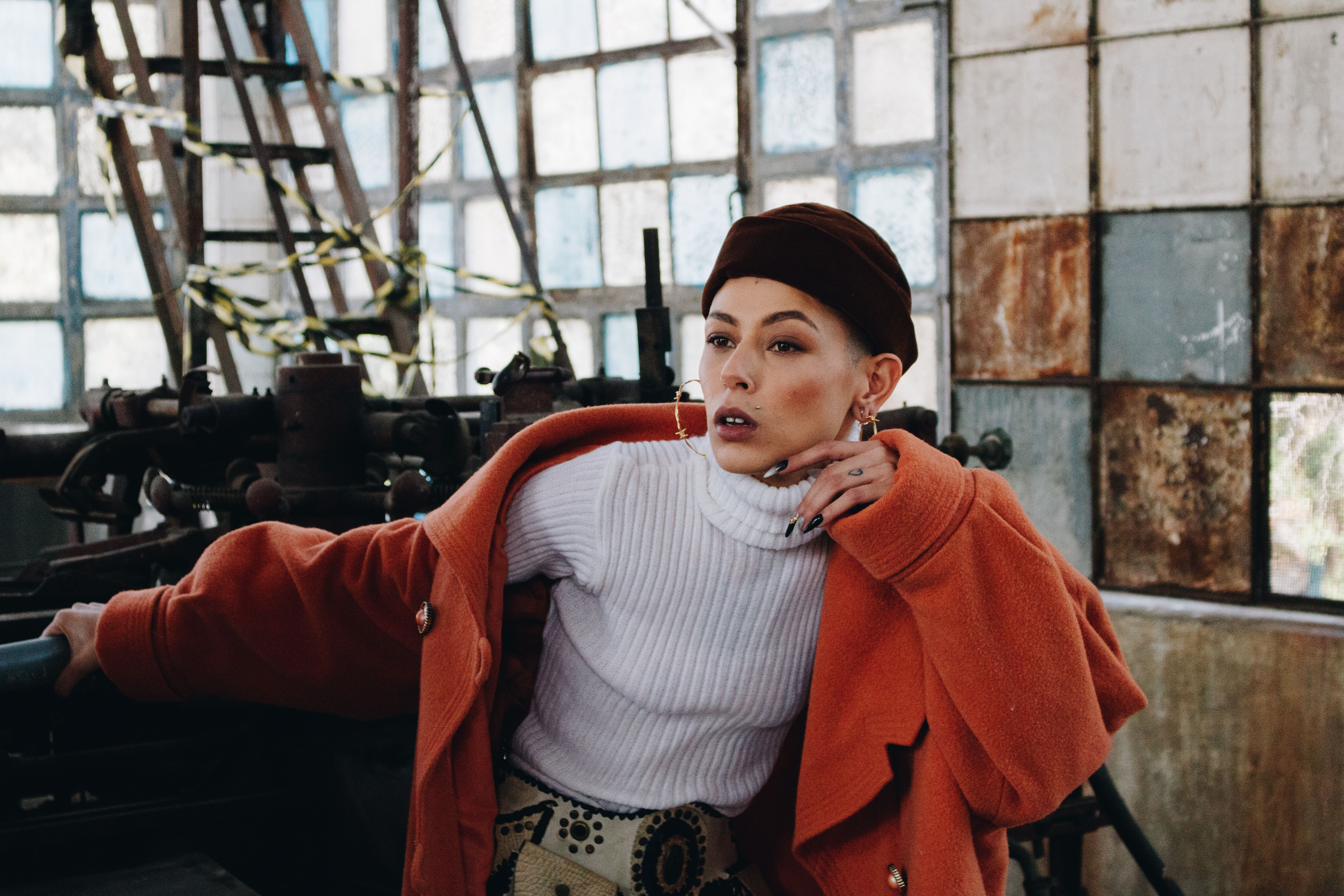 Woman in a bright orange coat in an editorial fashion portrait