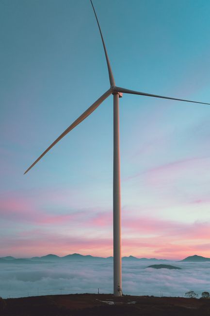 Majestic wind turbine set against a colorful sunrise in Dalat, Vietnam.