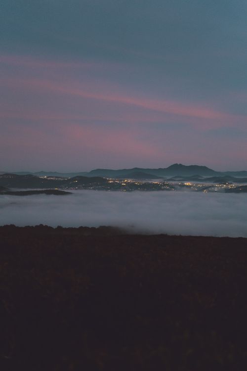 Free Serene view of Dalat's misty landscape at twilight showcasing hills and town lights. Stock Photo