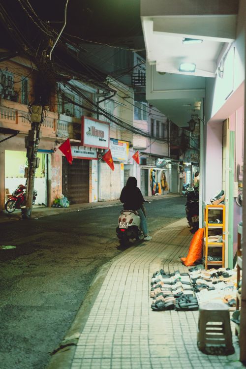 Free Person on a scooter in the quiet streets of Dalat, Vietnam at night. Stock Photo