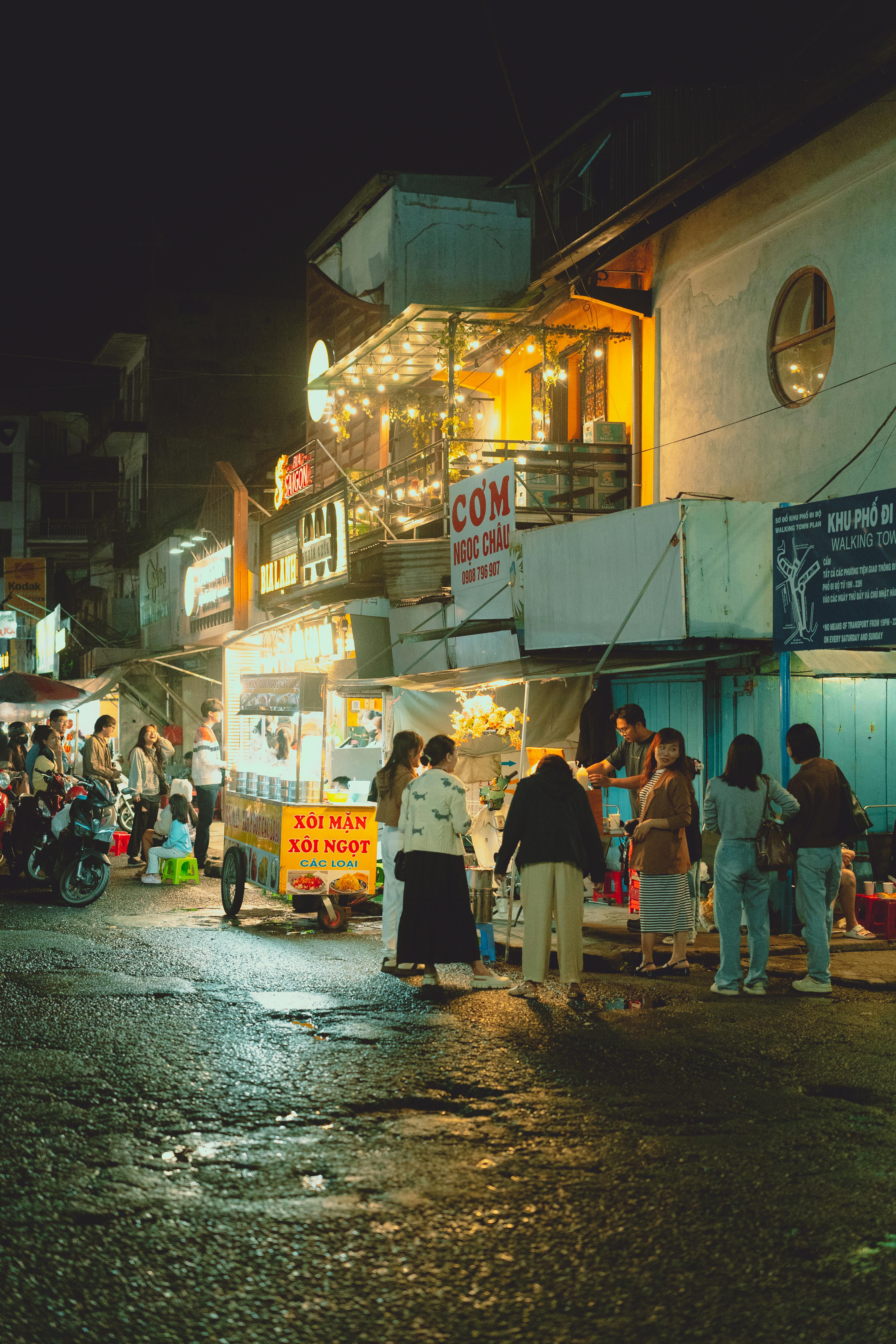 people walking down a street at night