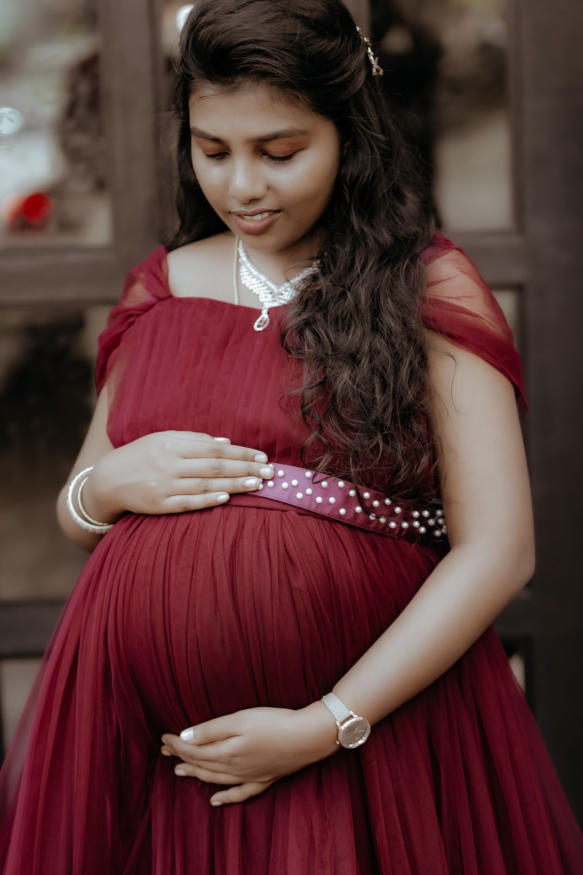 mermaid maternity dress hire Melbourne — elegant pregnant woman red fitted gown studio editorial Craigieburn VIC 3064