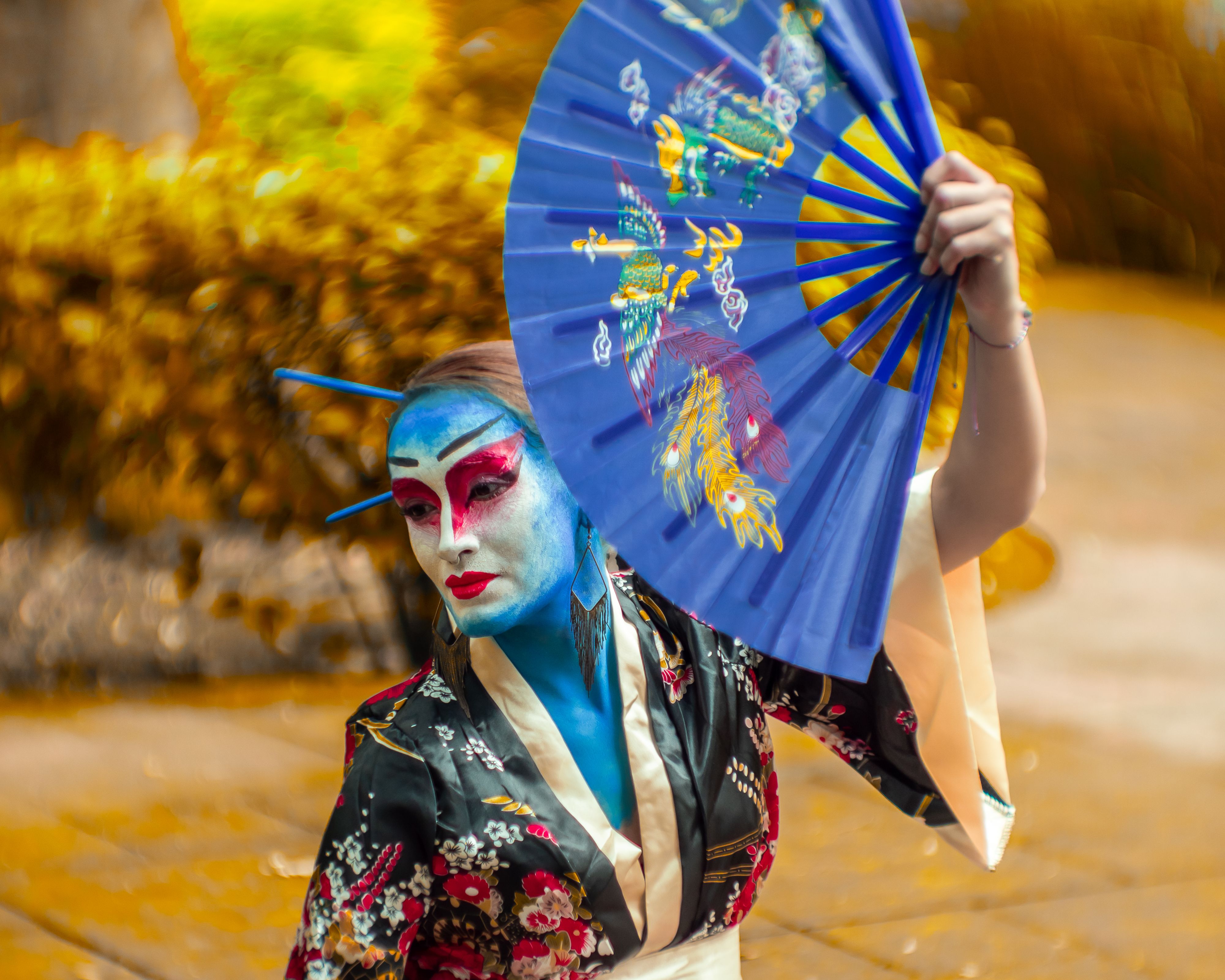 Colorful street performer in Japanese-inspired costume and makeup in Mexico City.