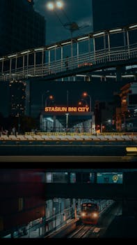 Illuminated BNI City train station in Jakarta at night with modern infrastructure.