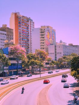 A lively summer city scene in Belo Horizonte, Brazil with colorful buildings and busy streets.