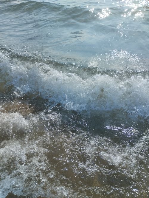 Free Captivating ocean wave crashing onto a sandy beach, creating a dynamic splash. Stock Photo