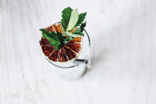 Glass Filled With Liquid With Slice Of Fruit And Straw