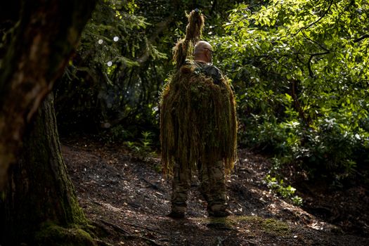 Man in Ghillie Suit in Forest