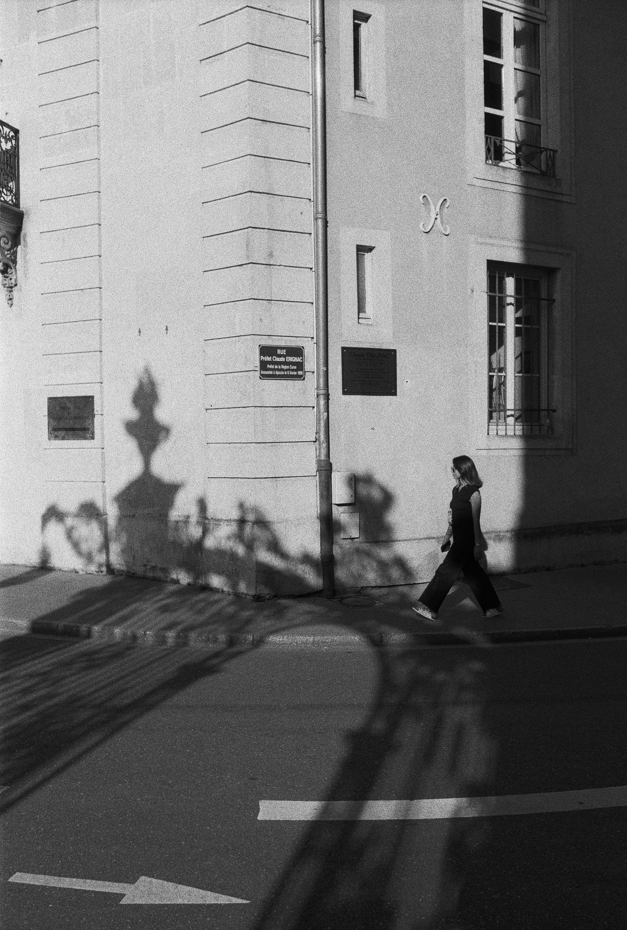 Black and White Photo of a Woman Walking on the Sidewalk · Free Stock Photo