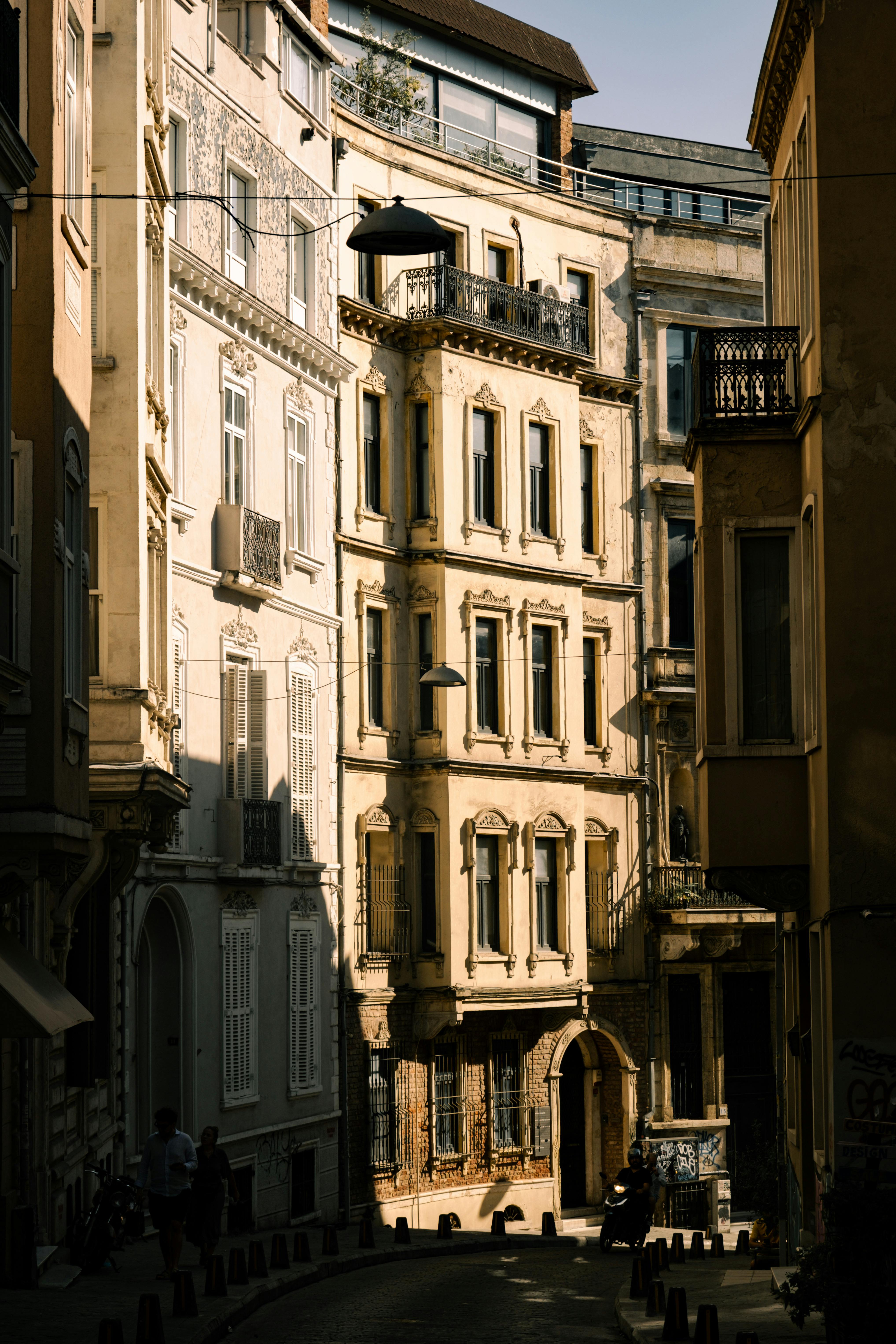Sunlit street showcasing vintage urban architecture and intricate facades.