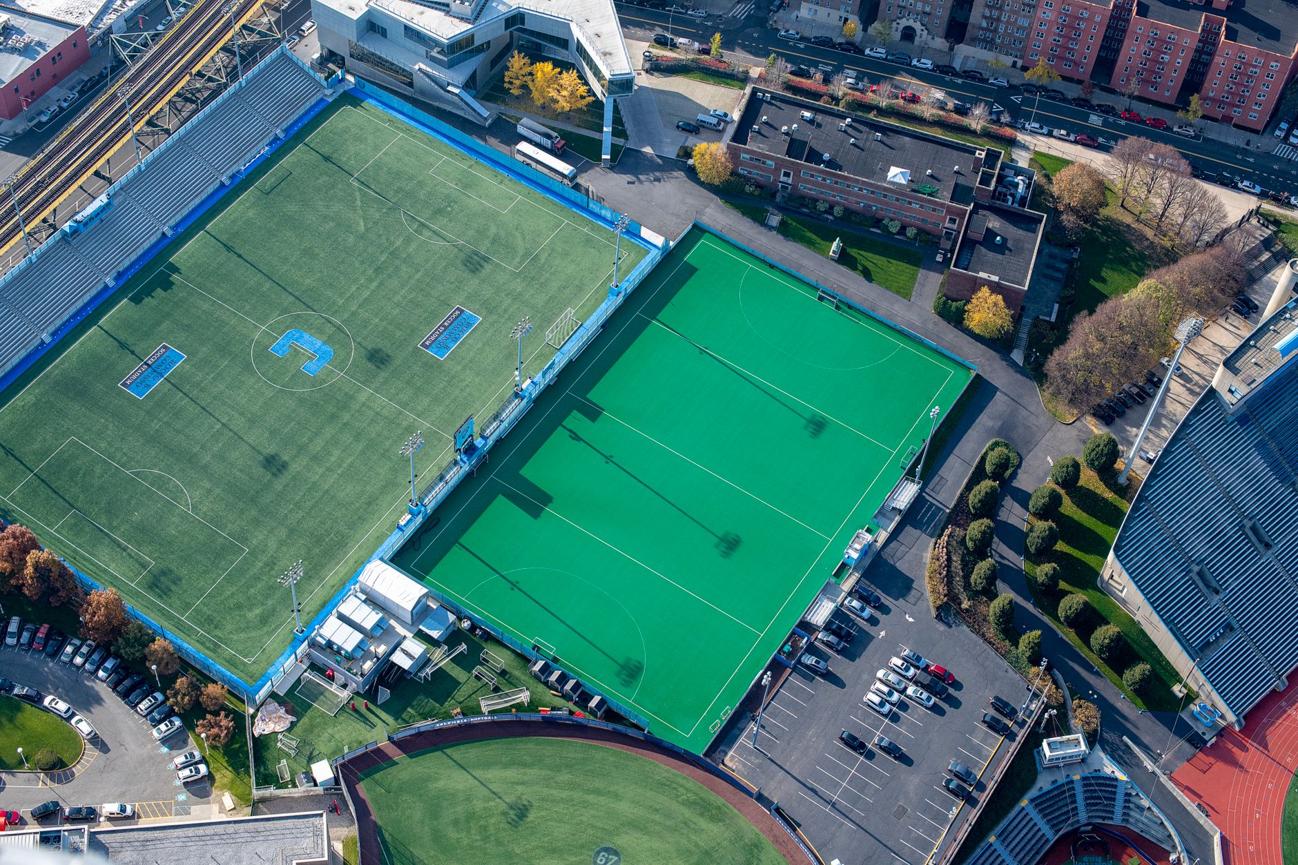 Aerial view of soccer and hockey fields in a city stadium complex.