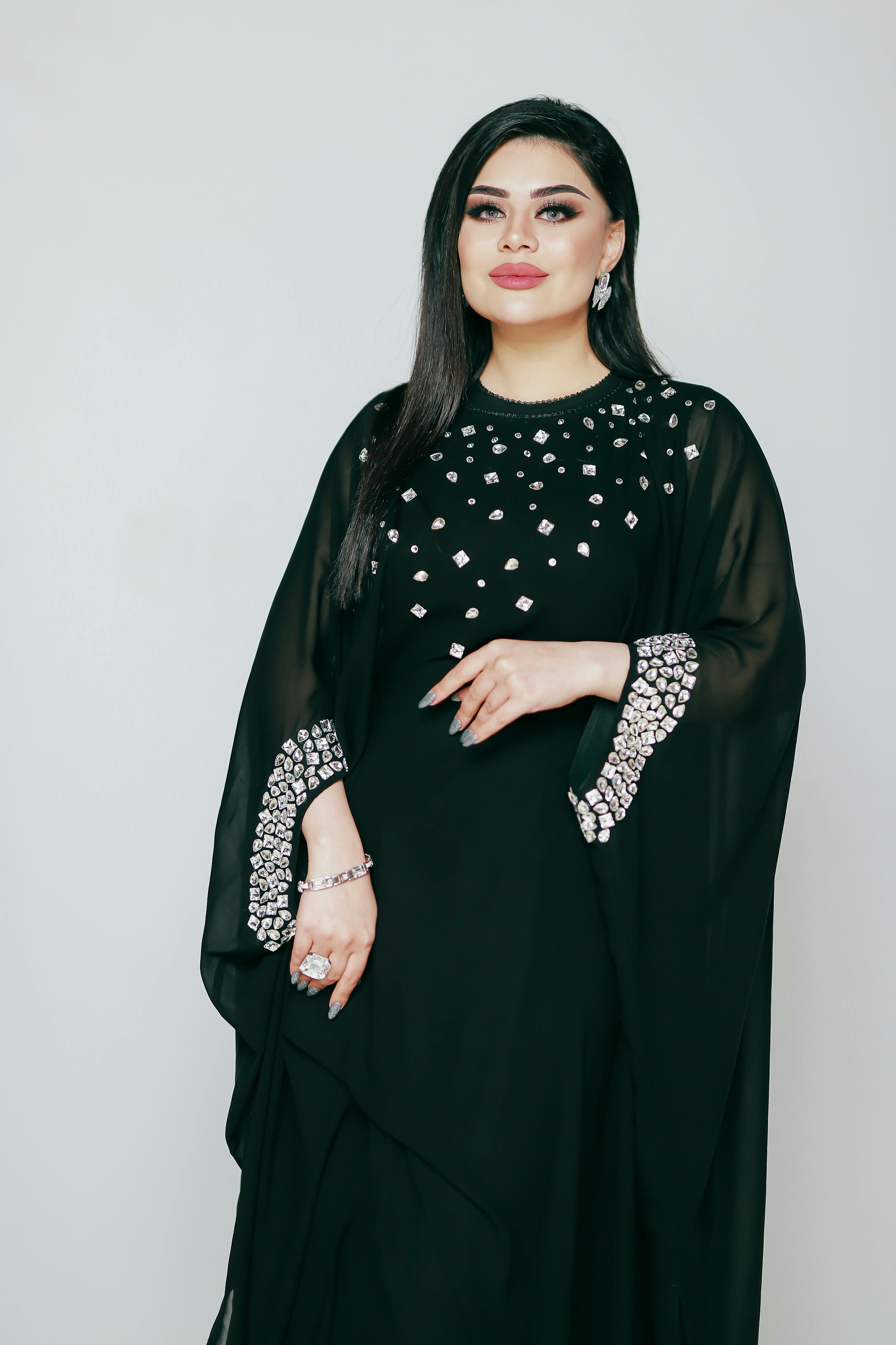 the black abaya is made from a soft fabric and has a long sleeve