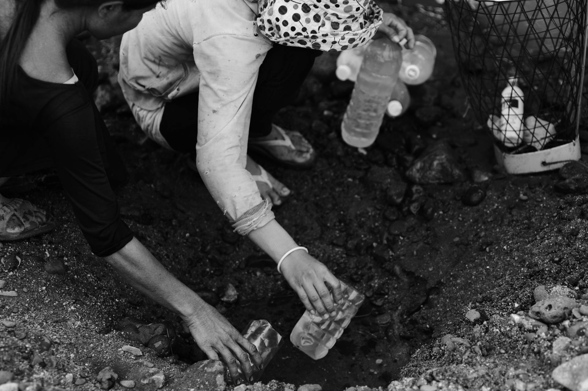 Women Sitting with Bottles of Water over Hole