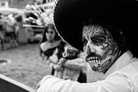 Black and white portrait featuring traditional Day of the Dead makeup and costumes, capturing Mexican culture.