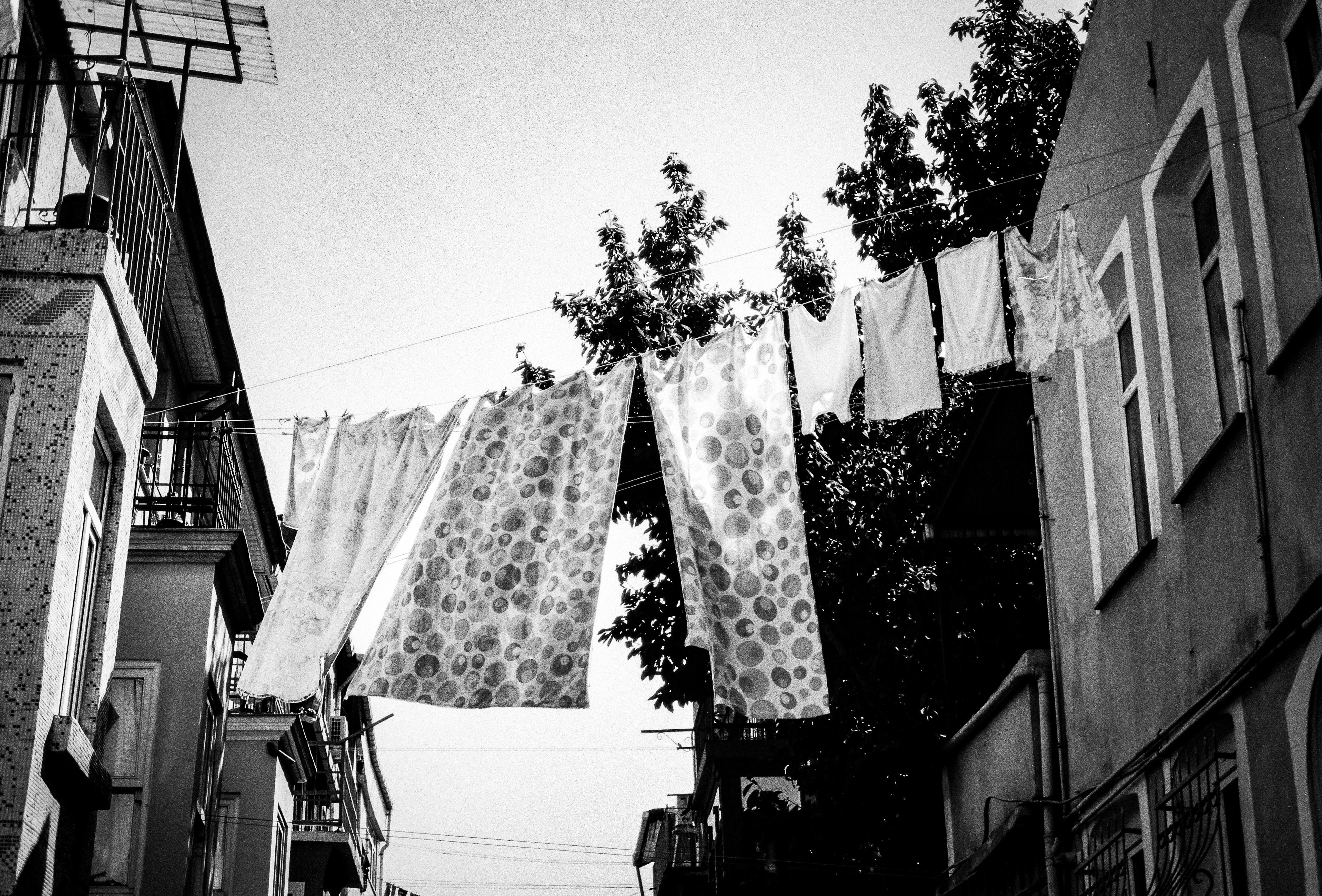 Black and white urban photo of laundry hanging between buildings in Istanbul, Türkiye.