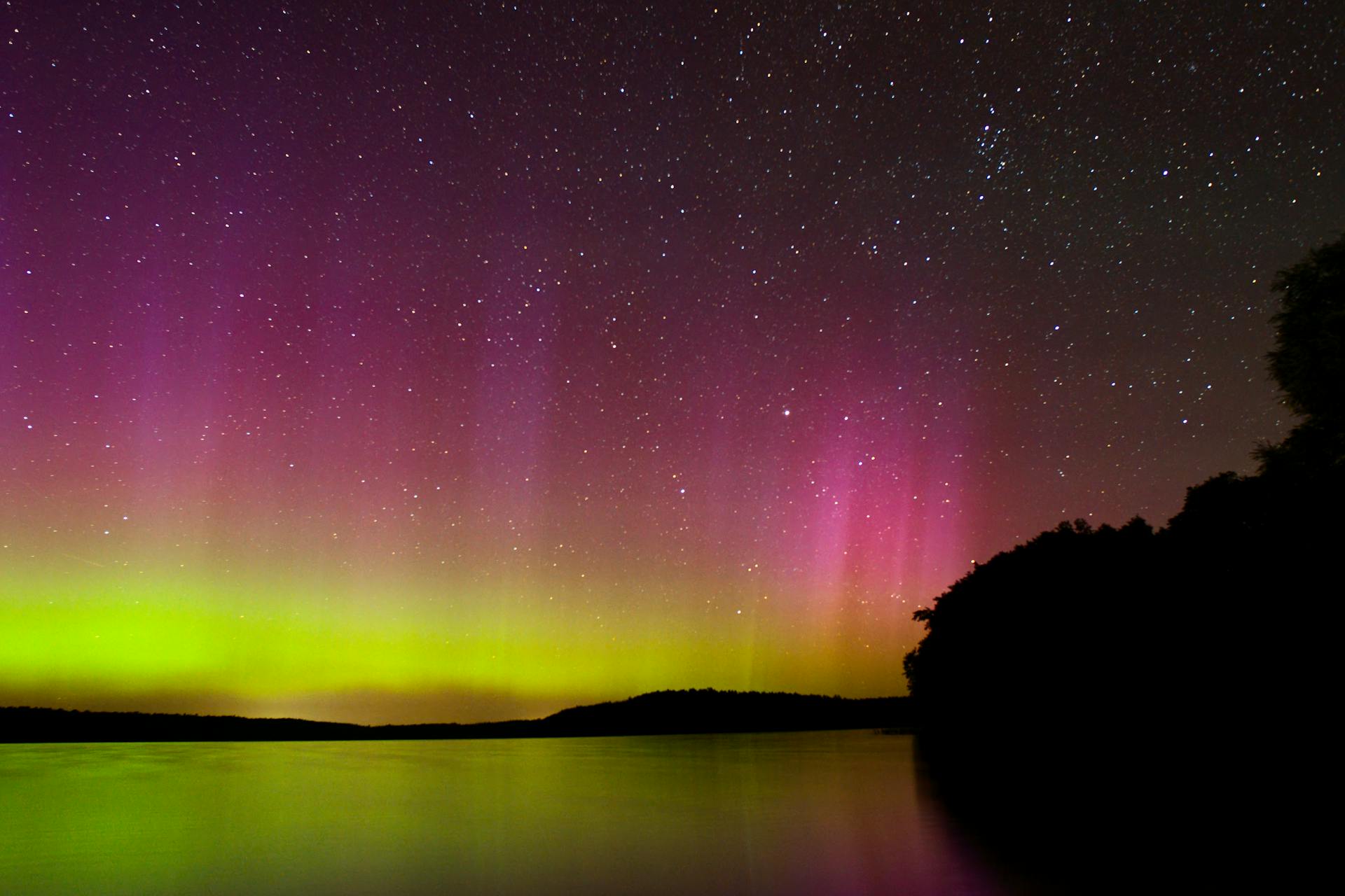 Pink Light of Aurora Borealis over Lake at Night