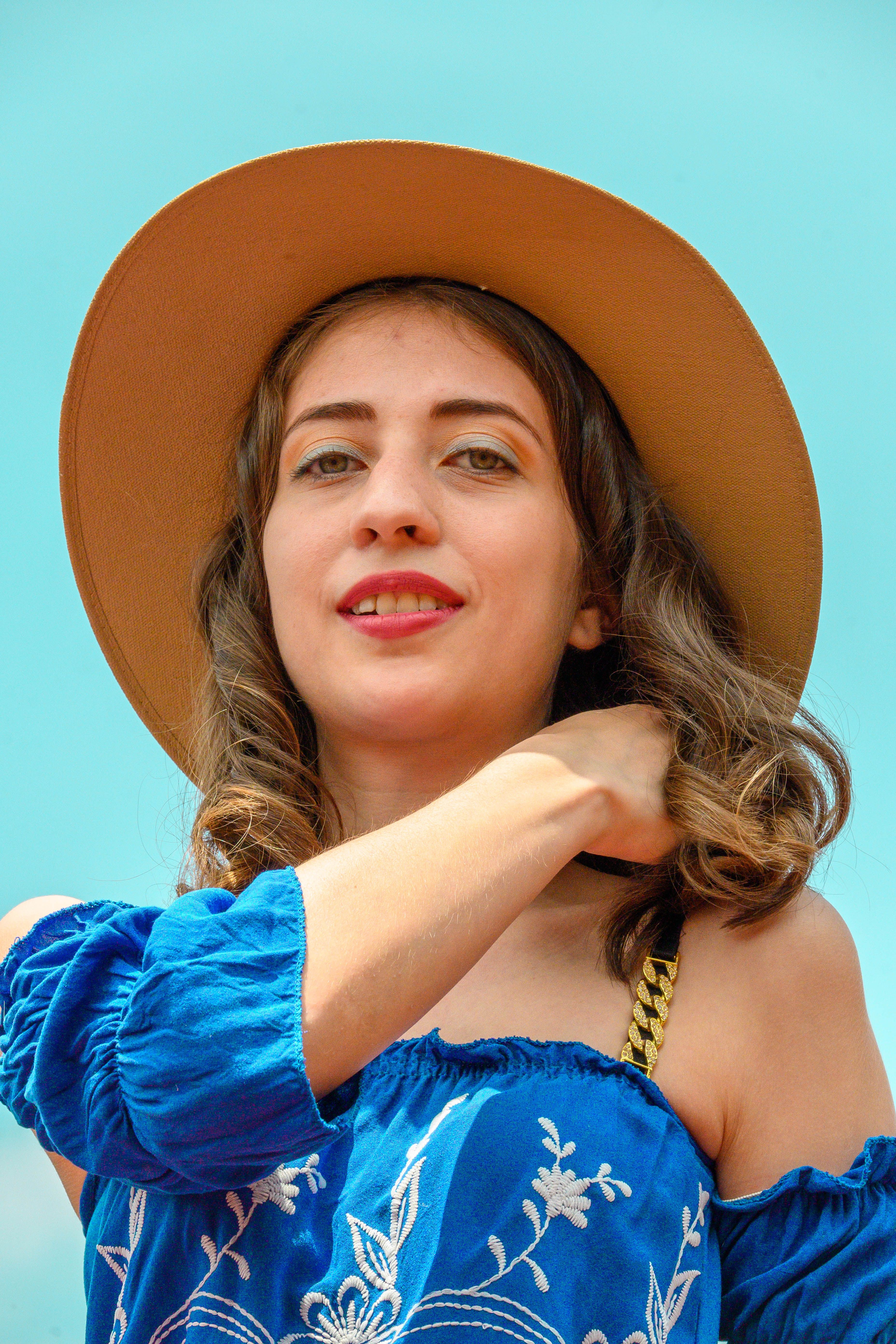 A woman in a blue dress and hat posing for a photo · Free Stock Photo