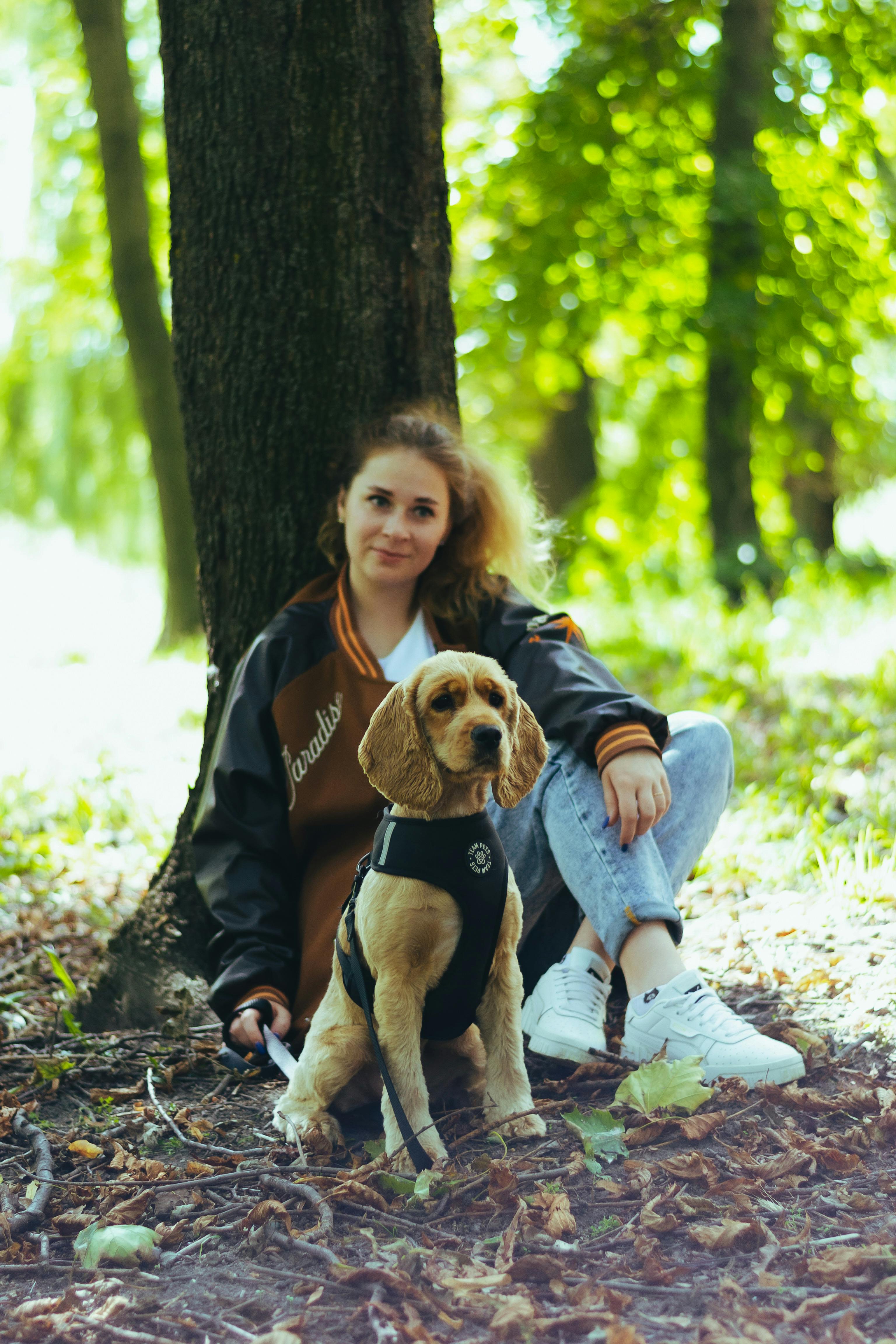 a woman sitting on the ground with her dog