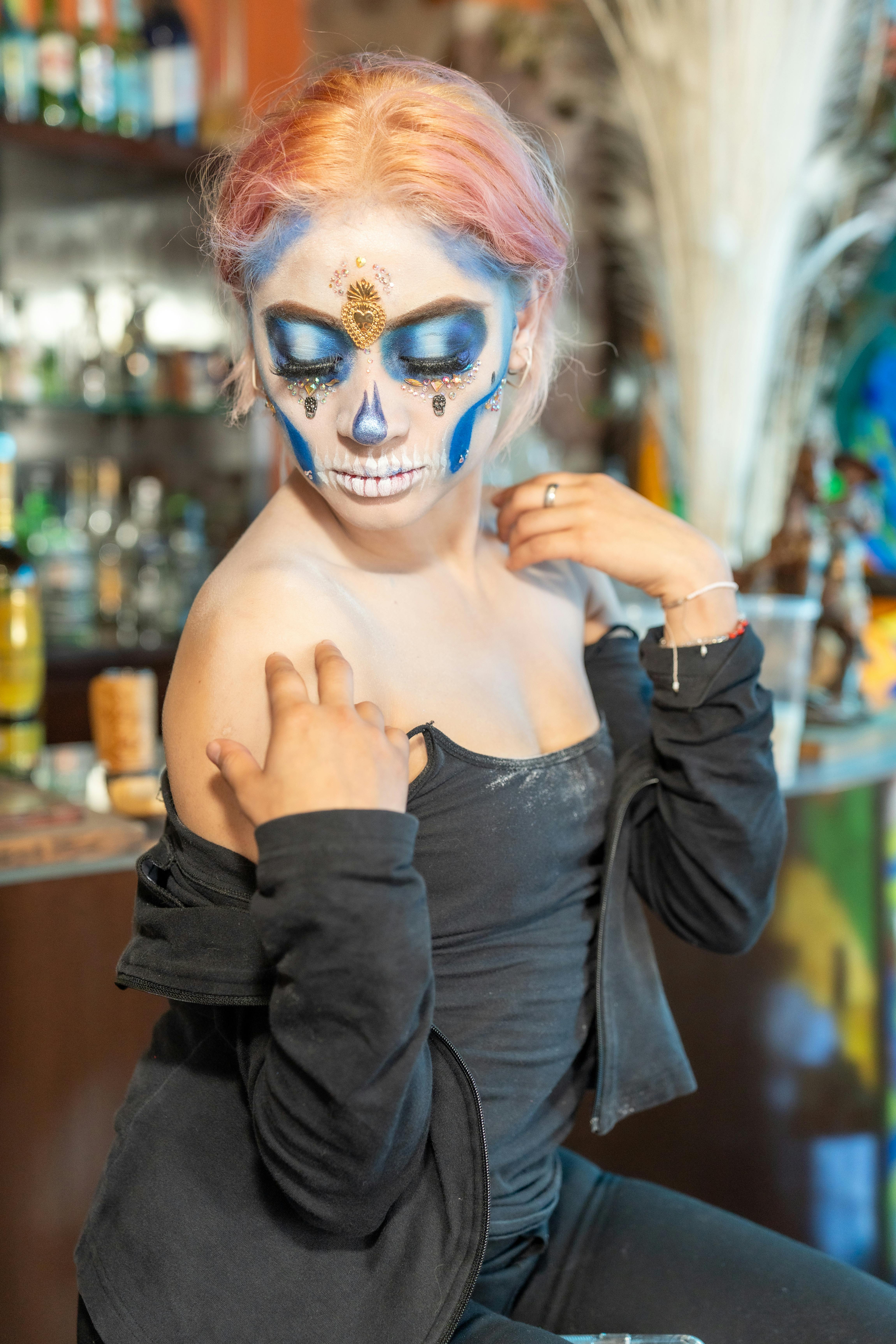 a woman with a skull makeup and pink hair