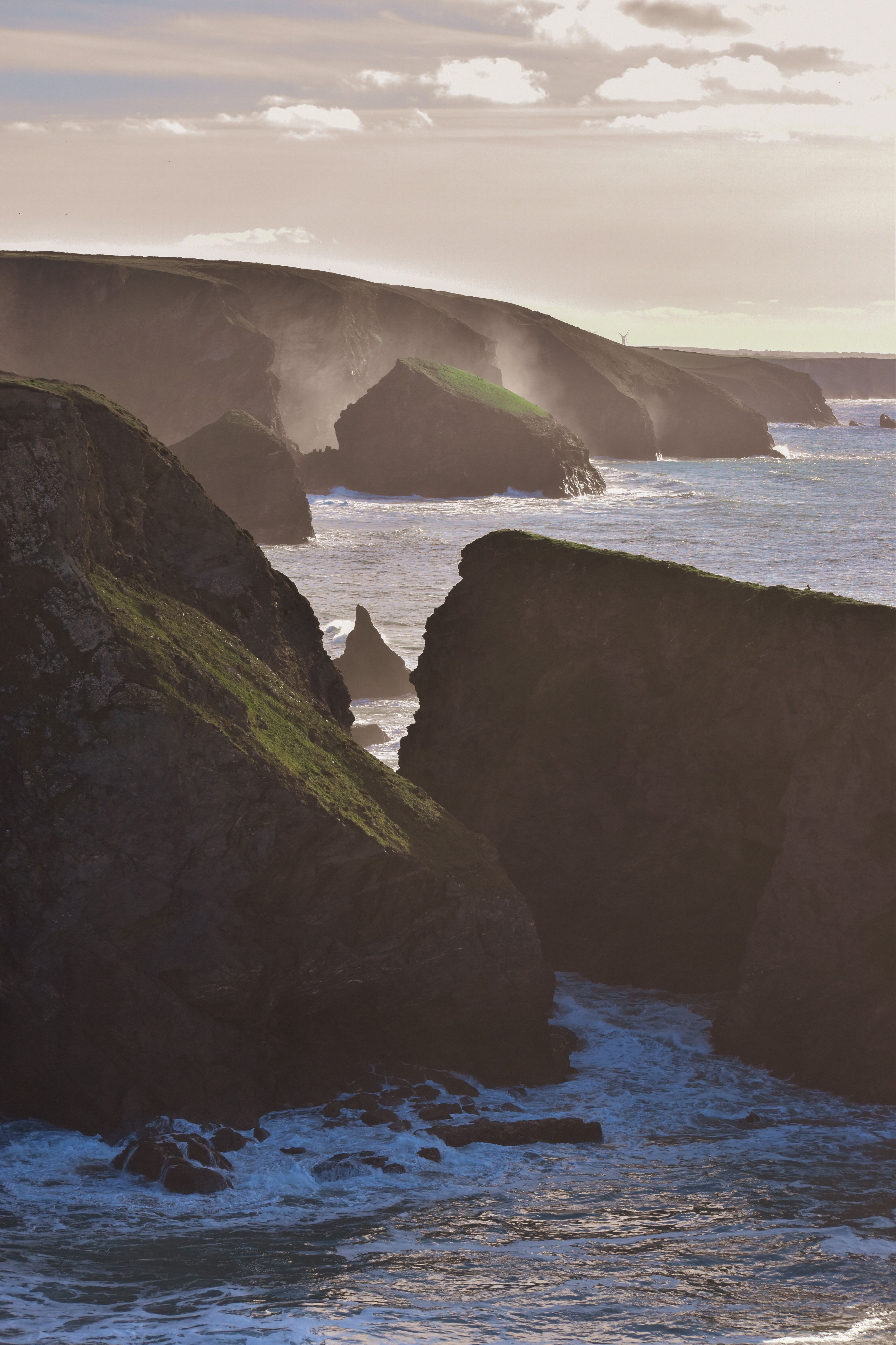 Majestic ocean view with rugged cliffs and serene sea at sunset, showcasing nature's beauty.