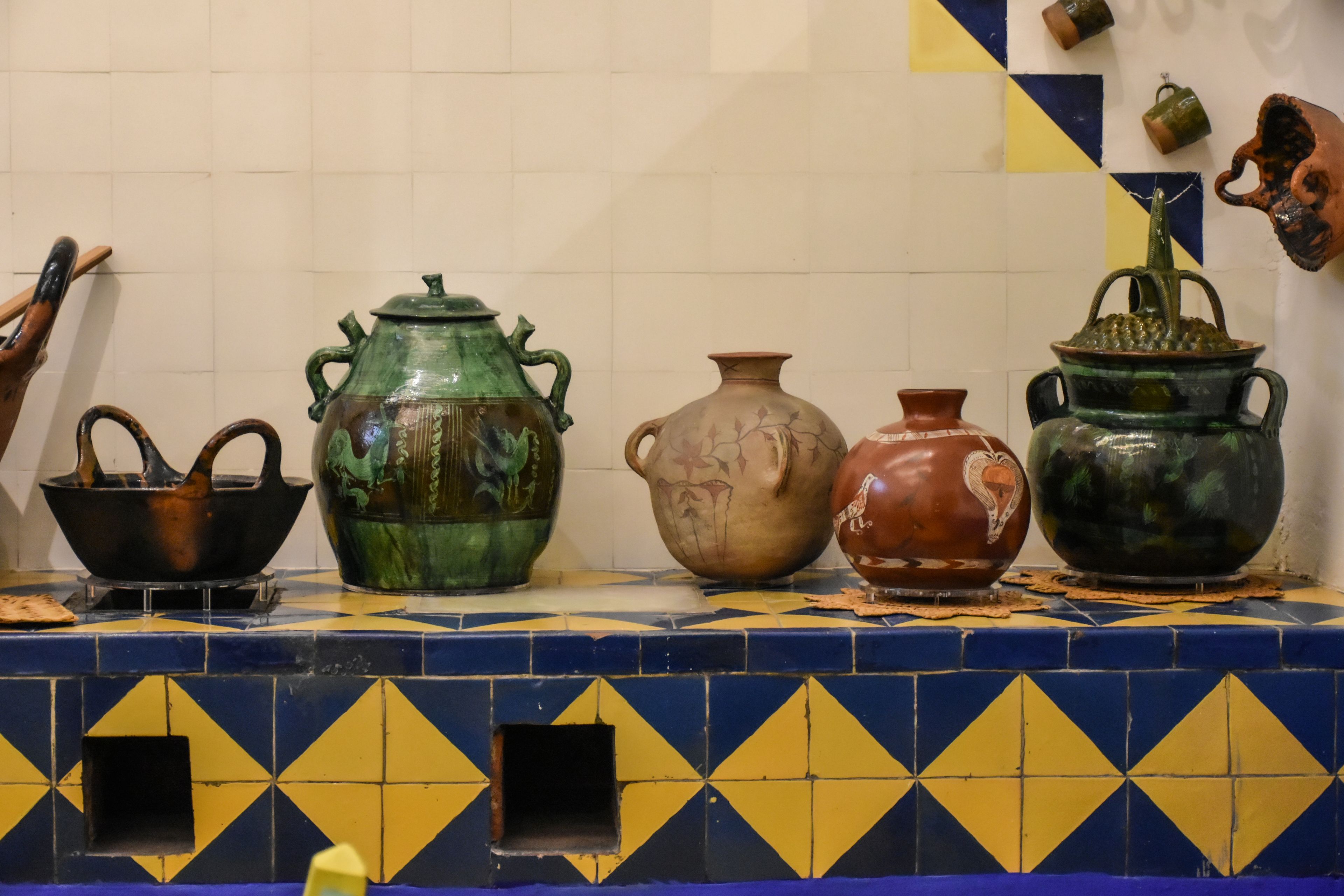 A collection of traditional Mexican ceramic pots on a tiled countertop in Mexico City.