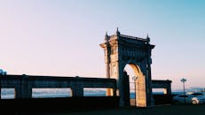 日落时分，伊斯坦布尔博斯普鲁斯海峡畔，一扇灯光明亮的历史大门附近停着汽车