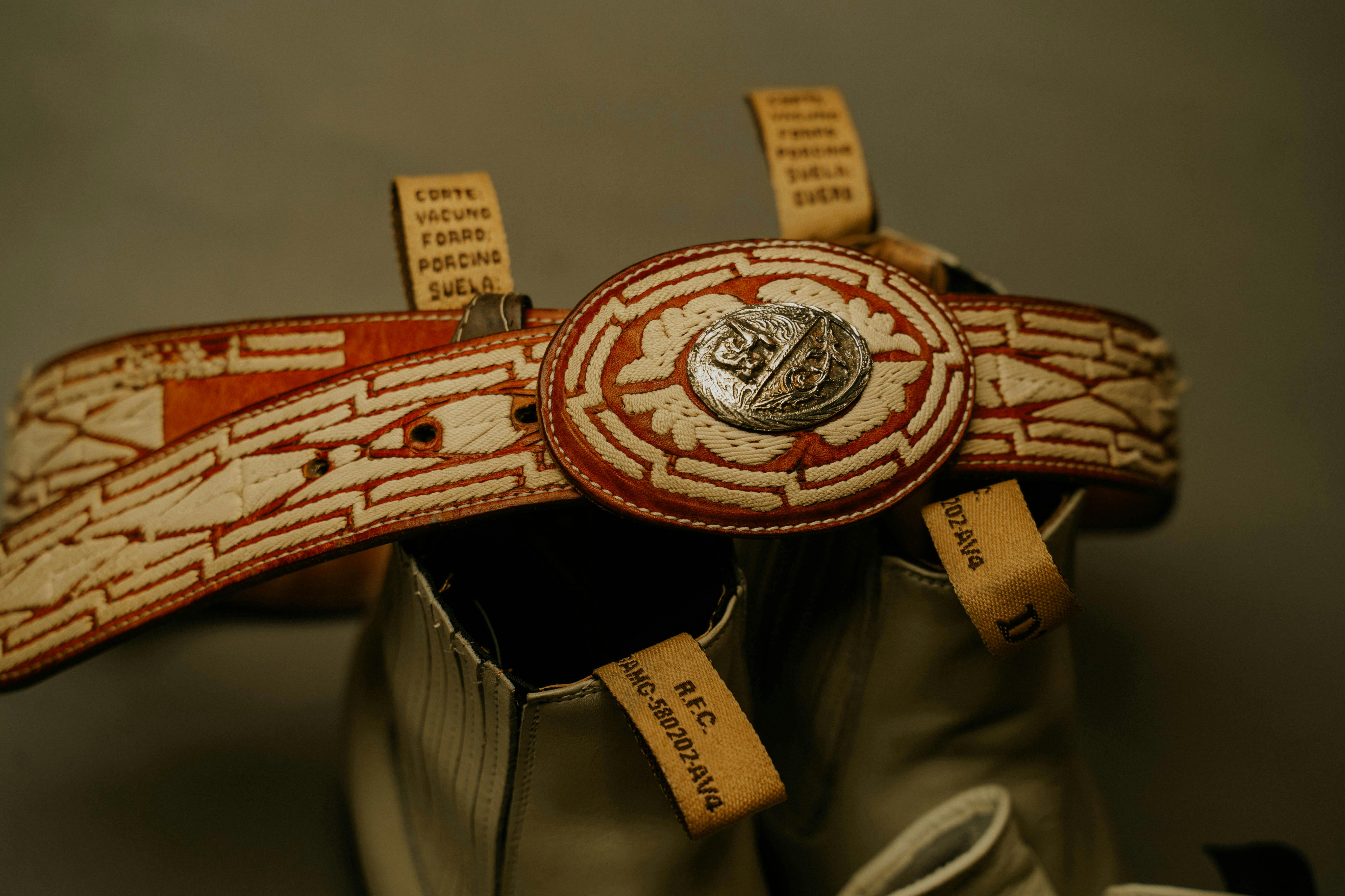 A hand-tooled leather cowboy belt with intricate floral patterns