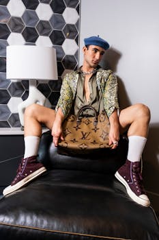 Fashion model posing indoors with luxury accessories and trendy attire.