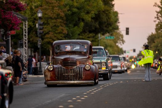 Classic Chevrolet truck leading a parade on a vibrant city street. Perfect blend of retro style and urban life.