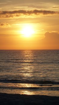 A beautiful sunset casting golden hues over Wrightsville Beach, NC ocean waves.