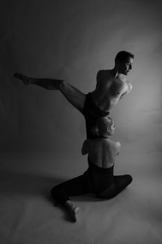 Elegant black and white photo of two dancers in a modern studio poses.