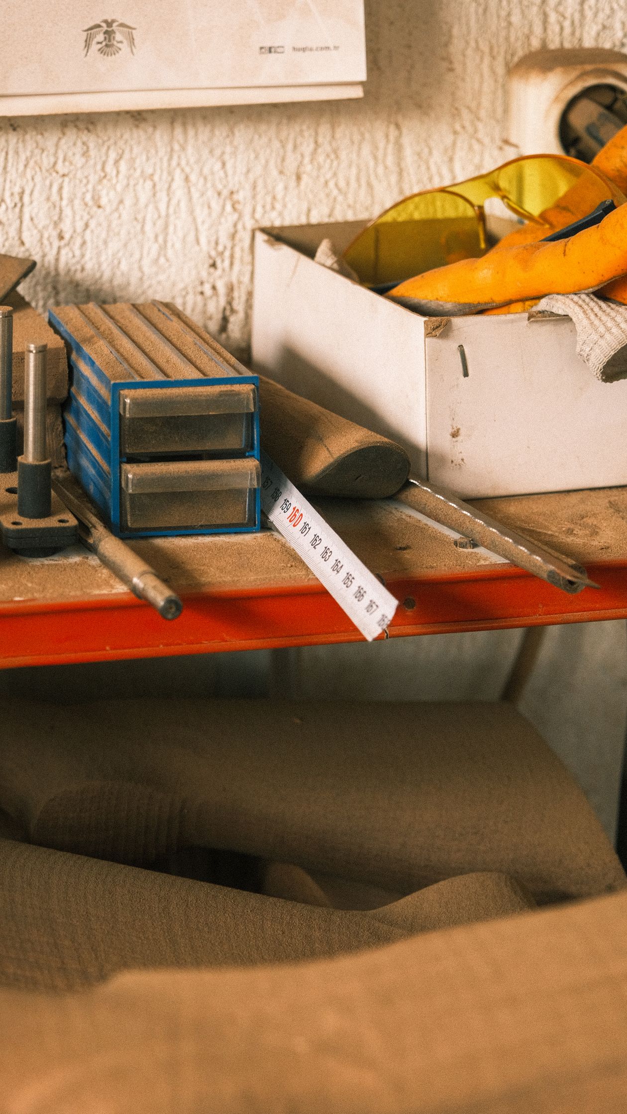 Tape measure checking a storage gap in a tiny bedroom.