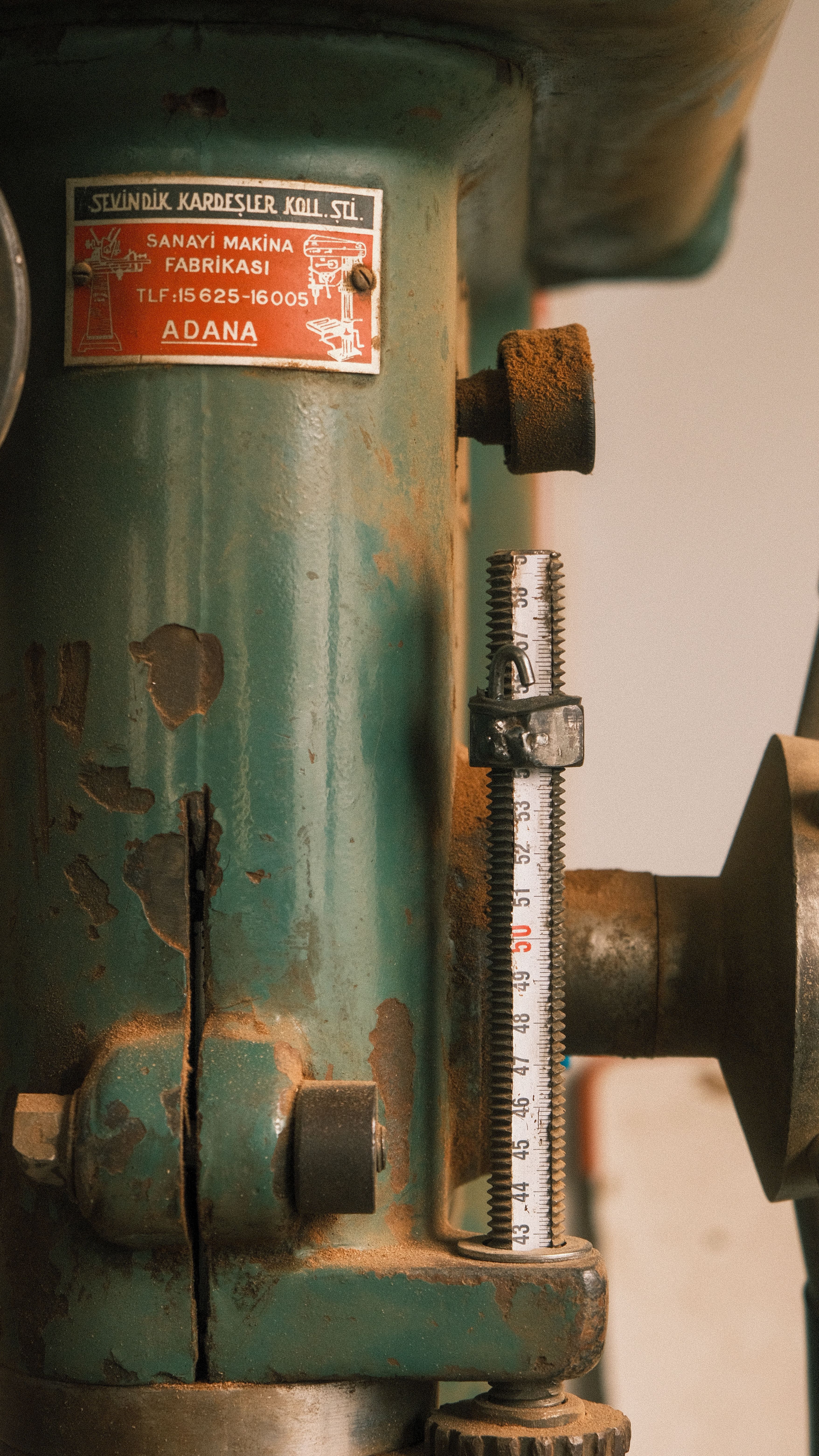 Close-up of vintage metalworking machinery with rust and wear, showcasing industrial history.