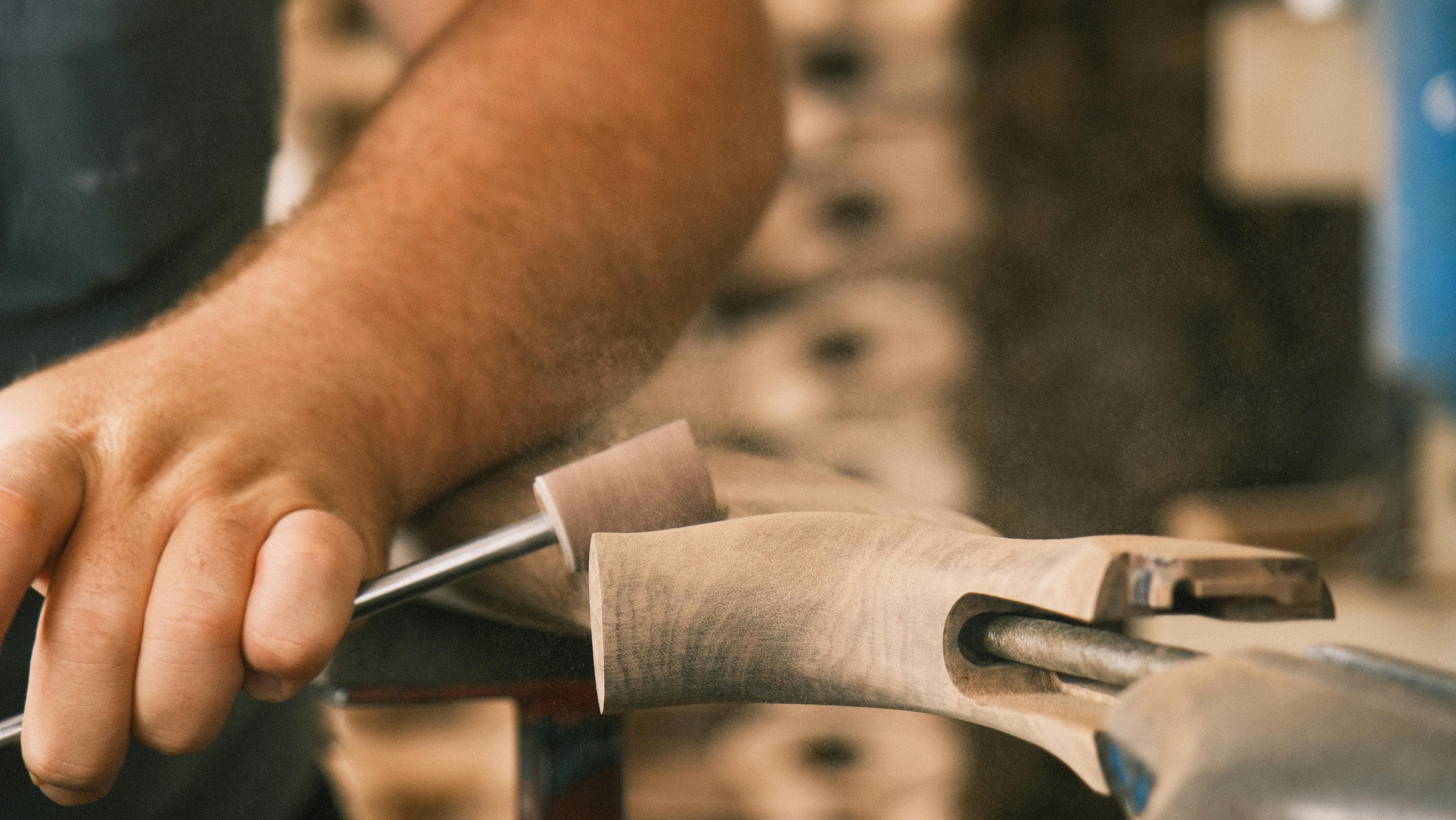 A skilled artisan meticulously carving wood with a chisel, showcasing craftsmanship and attention to detail.