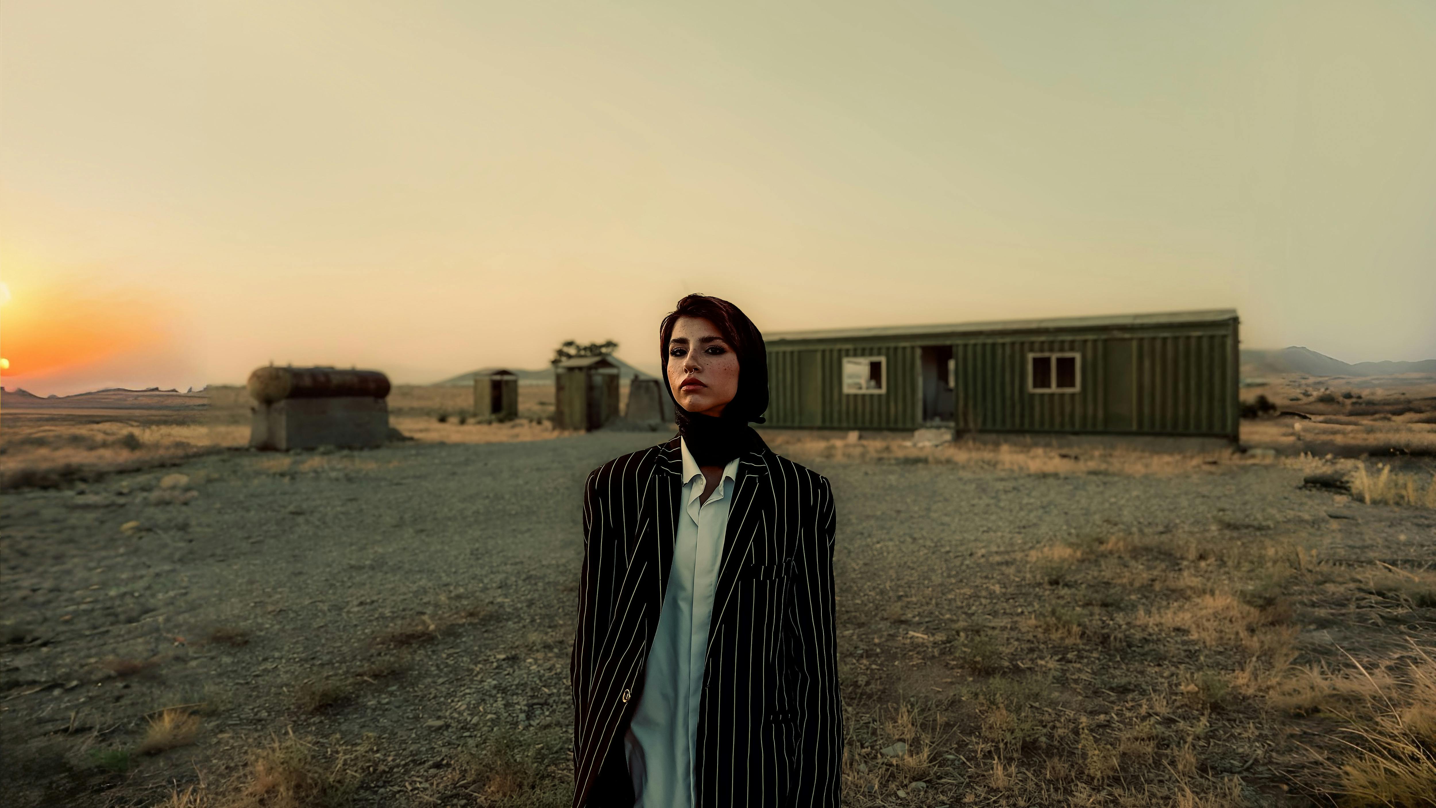 a woman standing in front of a building in the desert