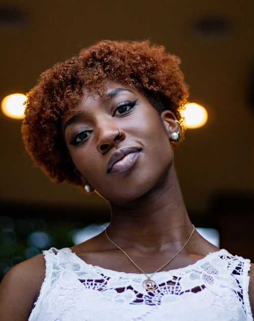 Free Close-up portrait of a stylish woman with natural hair and elegant attire, taken in Berlin. Stock Photo