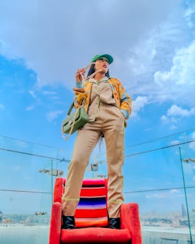 Stylish woman in colorful outfit posing against vibrant sky in Ciudad de México.